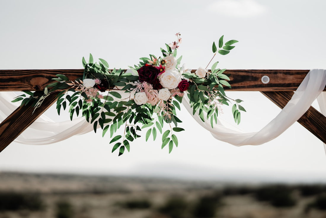 Beautiful wedding arch decorated with flowers and greenery — custom wedding signage by Iconica Design